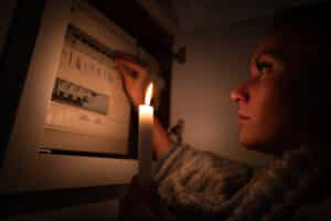 woman checking fuse box home during power outage blackout no electricity concept