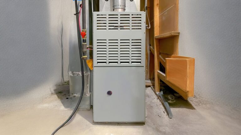 Close-up view of a furnace gas valve part, showing inlet, outlet, and control connections