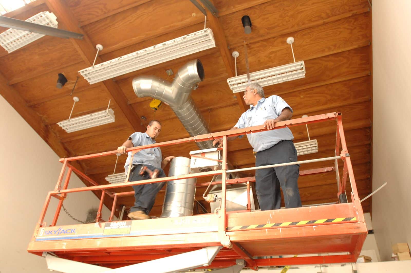 Air-Tro technician performing functional performance testing on commercial HVAC rooftop unit in Los Angeles building