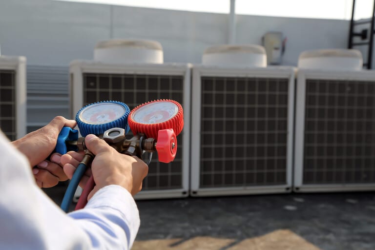 commercial hvac summer preparation Commercial HVAC technician conducting summer peak demand preparation maintenance on a rooftop unit in Los Angeles