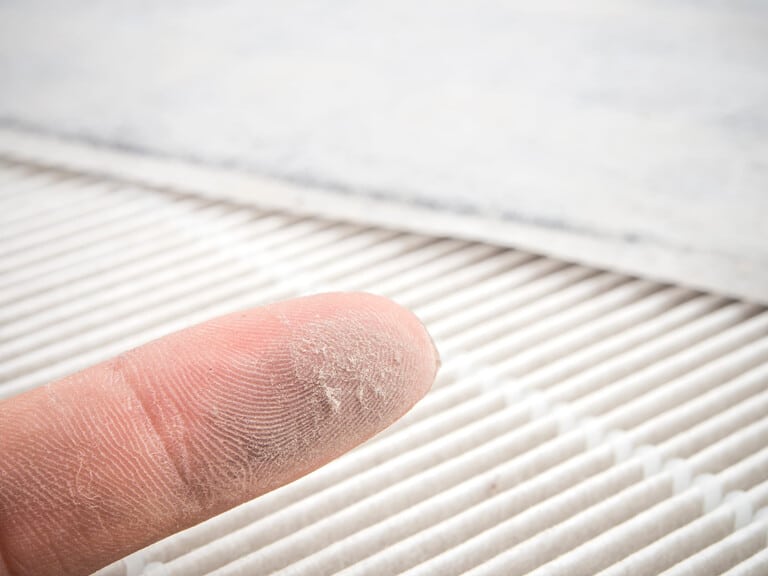Homeowner checking HVAC filter during wildfire smoke season in the Greater Los Angeles area